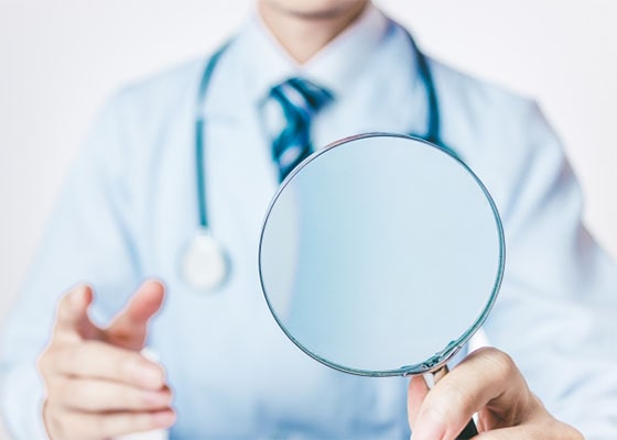 ルーペを持つ男性医師